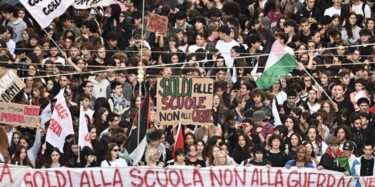 Bild von einer Demo in Italien am 16.10.2026. Im Vordergrund ein Transparent, das "Geld für die Schule, nicht für den Krieg. Studierende vereinigt gegen die Regierung. 30. Oktober Generalstreik" (auf Italienisch) lautet.